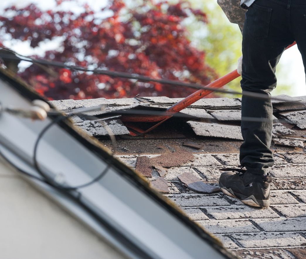 Roofer replacing shingles on a roof